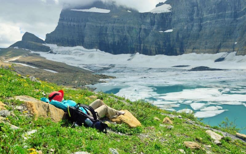 Hiker in summer resting by Grinnell glacier, Glacier National Park, Montana