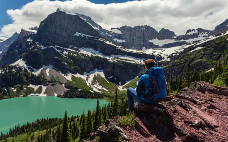 Hiker resting at Grinnell Lake, Glacier National Park, Montana