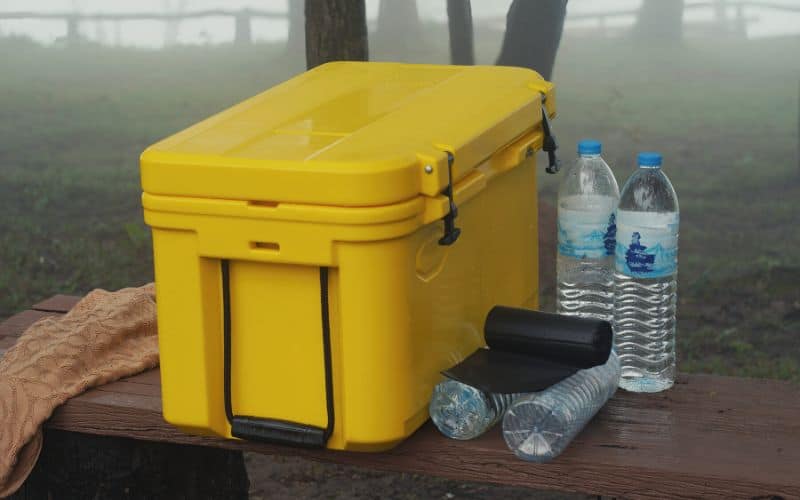 Hard sided, rotomolded camping cooler on bench